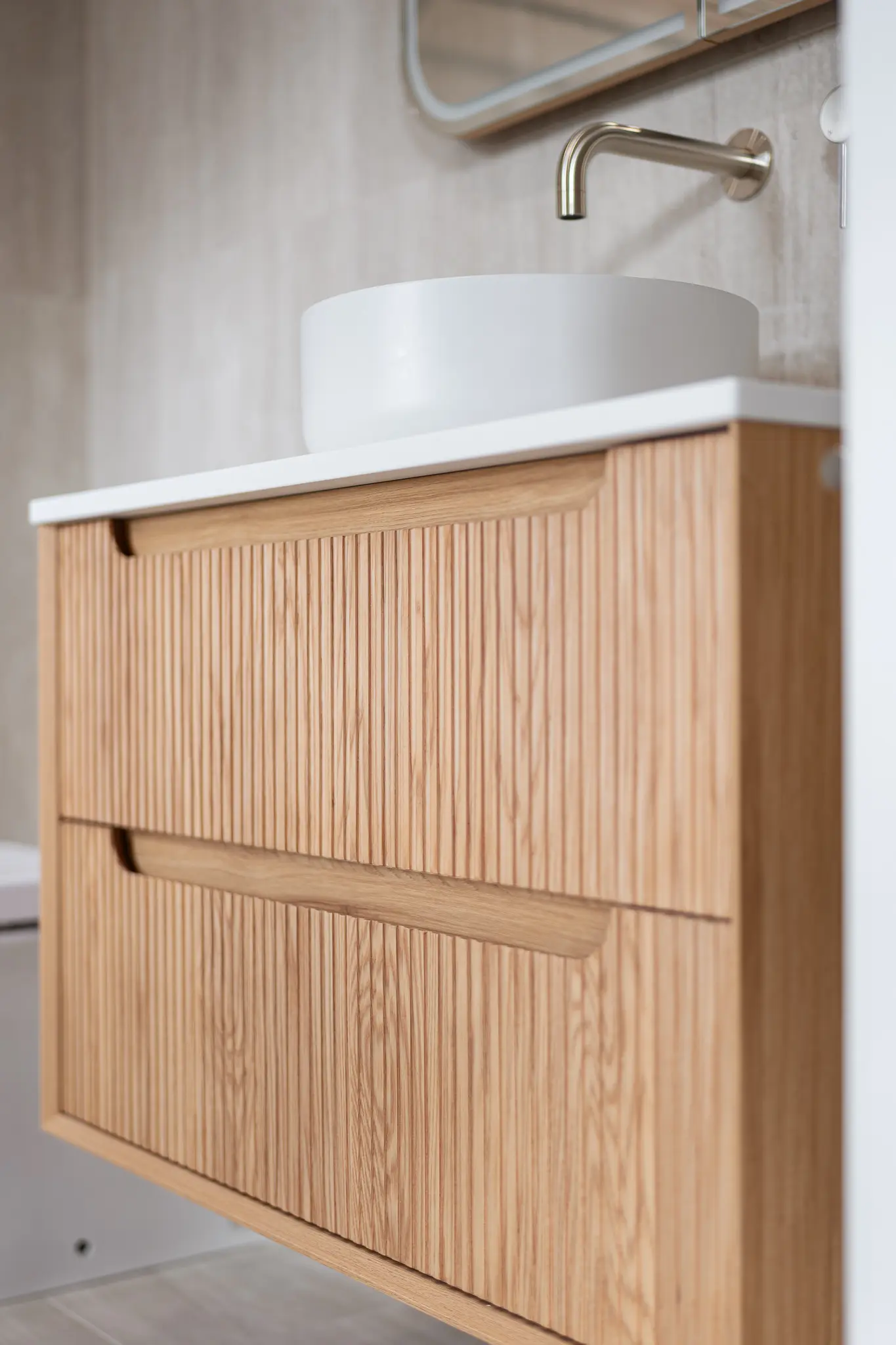 Close-up of a fluted timber vanity with stone benchtop